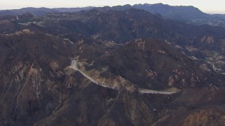 CAP_018_016 - HD stock footage aerial video of flying by road and tunnels by mountains scarred by fire, Malibu, California