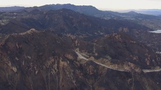 CAP_018_017 - HD stock footage aerial video of passing road and tunnels by mountains scarred by fire, Malibu, California