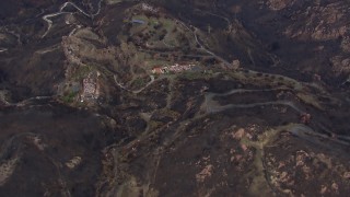 CAP_018_022 - HD stock footage aerial video of approaching hillside homes destroyed by fire, Malibu, California
