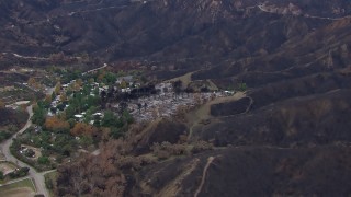 CAP_018_029 - HD stock footage aerial video of flying toward homes destroyed by fire by scorched mountains, Malibu, California