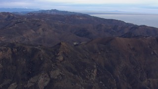 CAP_018_040 - HD stock footage aerial video of approaching mountains scorched by fire, Malibu, California