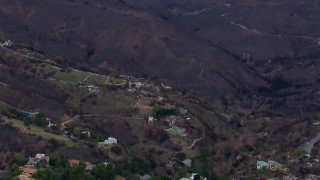 CAP_018_043 - HD stock footage aerial video of mountains scorched by fire near, zoom in to fire-damaged homes, Malibu, California