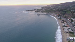 CAP_018_056 - HD stock footage aerial video of flying away from neighborhoods and Malibu Pier at sunset, California