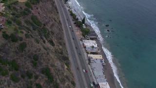 CAP_018_060 - HD stock footage aerial video of following light traffic on PCH at sunset, flyby Malibu homes, California