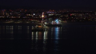 CAP_018_114 - HD stock footage aerial video approach the Ferris wheel and rides at night, Santa Monica Pier, California