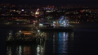 CAP_018_115 - HD stock footage aerial video fly toward the Ferris wheel and rides at night, Santa Monica Pier, California