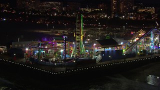 CAP_018_120 - HD stock footage aerial video circling the Ferris wheel and rides at nighttime, Santa Monica Pier, California