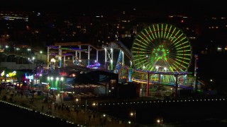 CAP_018_123 - HD stock footage aerial video flying around the Ferris wheel and rides at nighttime, Santa Monica Pier, California