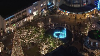 CAP_018_163 - HD stock footage aerial video of orbiting Christmas decorations and fountain at The Grove shopping mall at night in Los Angeles, California