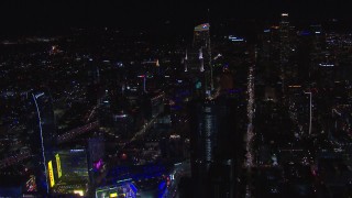 CAP_018_198 - HD stock footage aerial video orbit hotel under construction at night, reveal Downtown Los Angeles skyline, California