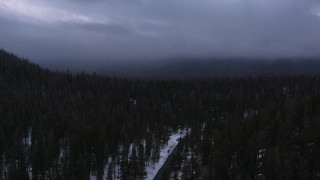 CAP_019_018 - 4K stock footage aerial video of following a road toward evergreen forest with snow, Inyo National Forest, California