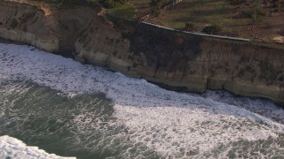 CAP_021_008 - HD stock footage aerial video of orbit waves rolling in toward coastal cliffs, Del Mar, California