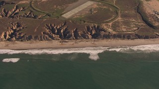 CAP_021_039 - HD stock footage aerial video of passing by an empty strip of beach as waves roll toward the coast, Oceanside, California