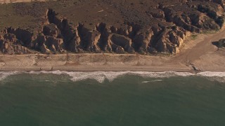 CAP_021_040 - HD stock footage aerial video of zooming to an empty strip of beach by cliffs on the coast, Oceanside, California