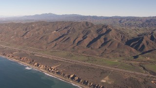 CAP_021_042 - HD stock footage aerial video of flying by I-5 between mountains and coastal cliffs, San Clemente, California