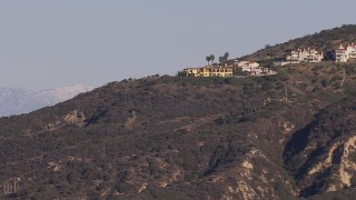CAP_021_065 - HD stock footage aerial video flyby hillside mansions to focus on distant snowy mountains in Dana Point, California