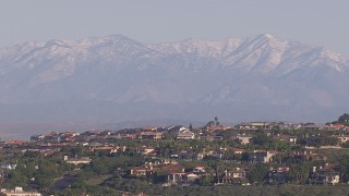 CAP_021_073 - HD stock footage aerial video of distant snowy mountains seen from hilltop mansions, Laguna Beach, California