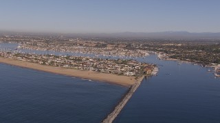 CAP_021_075 - HD stock footage aerial video of passing by the inlet to the bay by coastal neighborhoods, Newport Beach, California