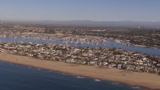 CAP_021_076 - HD stock footage aerial video of flying by the beach and bay by coastal neighborhoods, Newport Beach, California