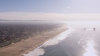 CAP_021_084 - HD stock footage aerial video of flying away from a pier and the beach in Huntington Beach, California
