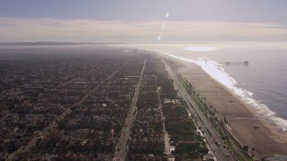 CAP_021_085 - HD stock footage aerial video of a reverse view of a pier and the beach in Huntington Beach, California