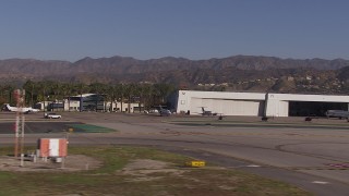 CAP_021_134 - HD stock footage aerial video of civilian jets and helicopters by aviation building and a Burbank Airport hangar, California