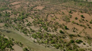 CAP_026_014 - HD stock footage aerial video approach and tilt to a village in open savanna, Zimbabwe