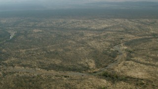 CAP_026_021 - HD stock footage aerial video of flying over open savanna, and tilting to a dry riverbed, Zimbabwe