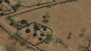 CAP_026_025 - HD stock footage aerial video of orbiting and flying away from a small village in the savanna, Zimbabwe