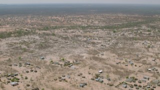 CAP_026_069 - HD stock footage aerial video of flying over a village with the savanna in the distance, Zimbabwe