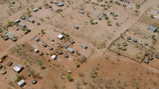 CAP_026_071 - HD stock footage aerial video of tilting to a bird's eye view of huts in a village, Zimbabwe