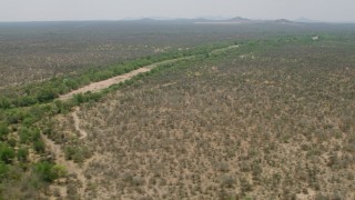 CAP_026_078 - HD stock footage aerial video of passing by a dry riverbed and trees in savanna, Zimbabwe