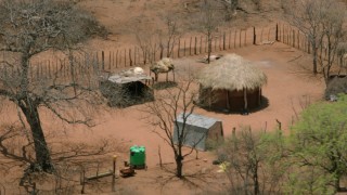 CAP_026_085 - HD stock footage aerial video of circling a wooden hut in the village, Botswana