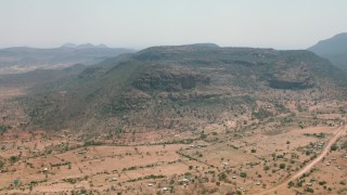 CAP_026_102 - HD stock footage aerial video of a village beside green mountains in Zimbabwe