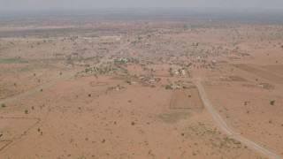 CAP_026_107 - HD stock footage aerial video of flying toward a road and tilt to reveal a village in Zimbabwe