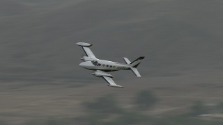 CBAX01_003 - HD aerial stock footage of tracking a Cessna 340 in flight, overcast day, Perris, California