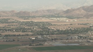 CBAX01_004 - HD aerial stock footage of tracking Cessna 340 banking over farmland on hazy day, Perris, California