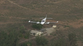 CBAX01_009 - HD aerial stock footage of flying over rural neighborhood, revealing Cessna 340, Perris, California