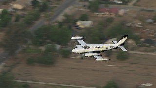 CBAX01_010 - HD aerial stock footage of tracking Cessna 340 over rural neighborhood, Perris, California