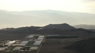 CBAX01_017 - HD aerial stock footage fly by farmland, hills, reveal Cessna 340 flying into frame, hazy, Perris, California
