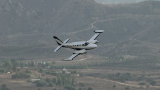CBAX01_019 - HD aerial stock footage of tracking Cessna 340 over hazy, rural countryside, Perris, California