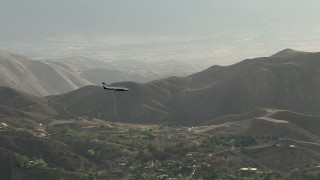 CBAX01_022 - HD aerial stock footage of tracking Cessna 340 over hazy hills, rural countryside, Perris, California