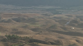 CBAX01_029 - HD aerial stock footage of a Cessna 340 flying across hazy hills, Perris, California
