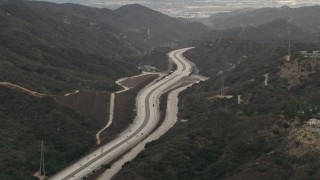 CBAX01_119 - HD aerial stock footage of flying by Interstate 210, light traffic, Tujunga, California