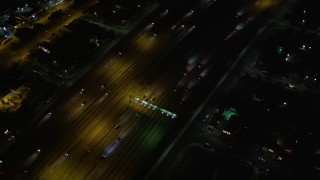 DCA01_066 - 5K aerial stock footage tracking traffic on Highway 110, tilt up to reveal Hwy 110/ I-105 interchange at night, Los Angeles, California