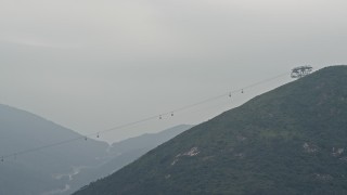 DCA02_002 - 4K aerial stock footage of the Ngong Ping Cable Car gondolas on Lantau Island, Hong Kong, China