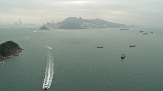 DCA02_009 - 4K aerial stock footage approach ferries and cargo ships near Hong Kong Island and Victoria Harbor, China