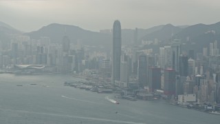 DCA02_015 - 4K aerial stock footage tilt from a ferry and pan across Hong Kong Island and Victoria Harbor to reveal Kowloon, China
