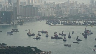 DCA02_016 - 4K aerial stock footage tilt from ships in Victoria Harbor to reveal Kowloon apartment complexes, Hong Kong, China