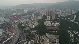 DCA02_018 - 4K aerial stock footage pan from Port of Hong Kong and office buildings to reveal Kwai Chung apartment buildings, Hong Kong, China